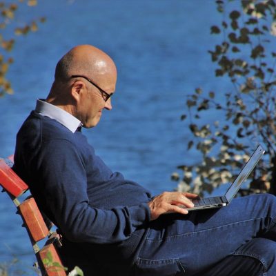 一位信息安全方向的审校者在笔记本上做批注，旁边摊开着打印出来的 tempmail 隐私条款资料，绿色便签标记着需要核实的关键段落